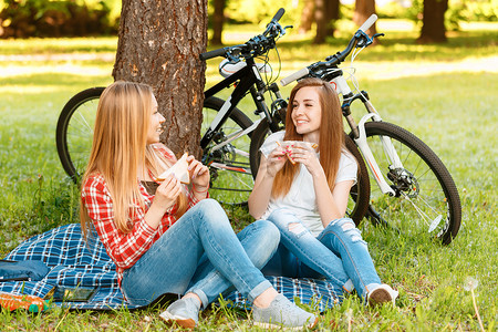 外出野餐摄影照片_外出野餐，自行车的两个女孩