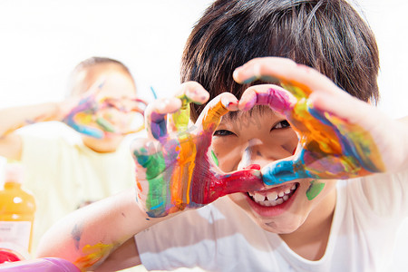 手上涂满颜料的小学生手比爱心