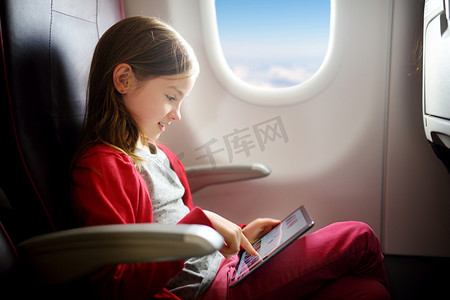 坐飞机的儿童摄影照片_儿童使用数字平板电脑