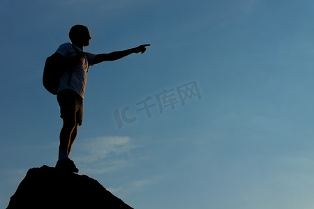 一个男人站在山顶的轮廓