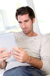 男人在家里放松与电子平板电脑