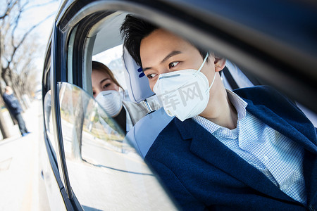 防护汽车摄影照片_青年情侣戴口罩乘坐汽车