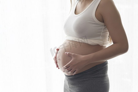 孕妇摄影照片_家中年轻漂亮的孕妇、产妇和孕期护理概念