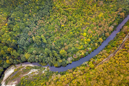 空中俯瞰河流，越过高山，长满了秋天的树木