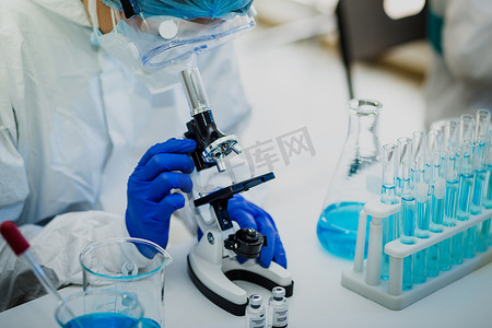 科学家或研究人员手拿蓝色手套，装有流感、麻疹、头孢病毒、眼镜蛇-19型疫苗，为人类临床试验接种疫苗、药物和药物概念做准备.