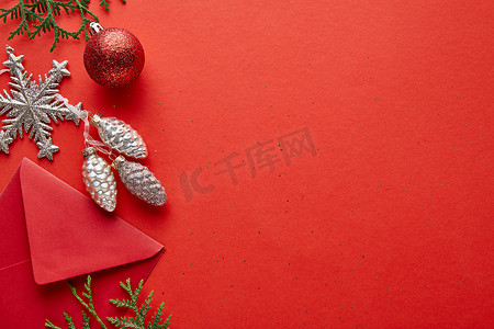 复印摄影照片_明亮的圣诞装饰、信封及带有复印空间的红色背景照片