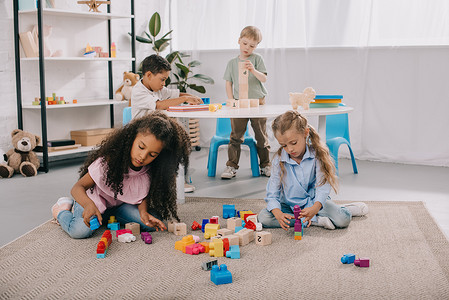 集中的多种族学龄前儿童在课堂上玩积木