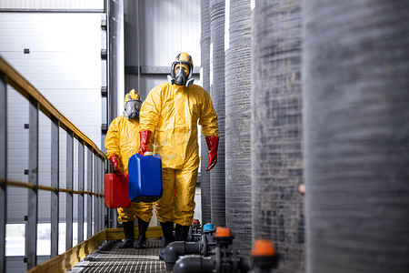 穿着黄色西装、防毒面具和手套处理危险化学品或物质的受到充分保护的工人.
