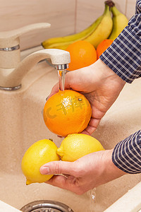 在厨房的水槽里洗水果.洗橙子和柠檬的手