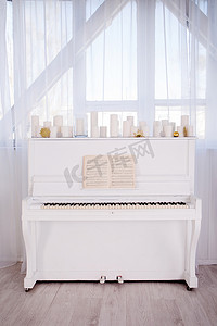 老式的白色乐器钢琴，用白色蜡烛装饰。圣诞节的概念