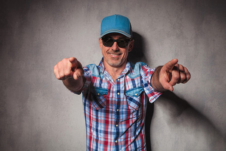 cool mature casual man with trucker hat  pointing his fingers
