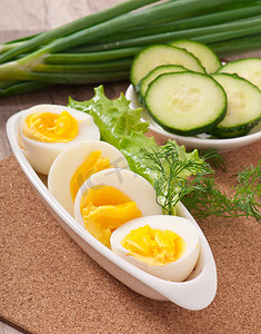 煮熟的鸡蛋摄影照片_白盘上煮熟的鸡蛋