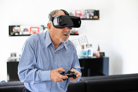 老年人快乐的男人带着虚拟现实的护目镜踢足球，戴着Vr眼镜的新技术概念 