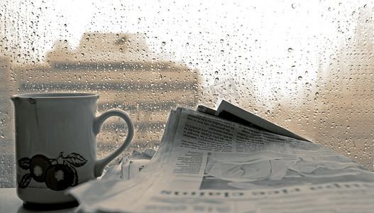 叫卖报纸摄影照片_冲杯咖啡，-报纸和窗外雨