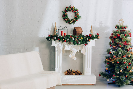靠近壁炉的沙发，毛毯，圣诞长袜和装饰过的松树