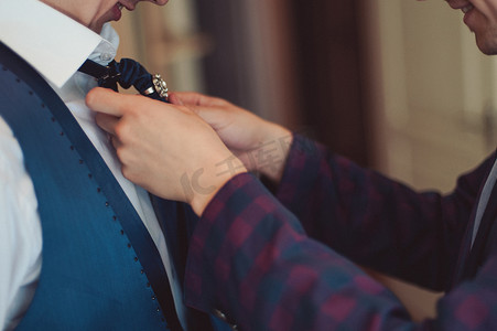 一套西装摄影照片_在一套西装新郎纠正一条领带。新郎的配件