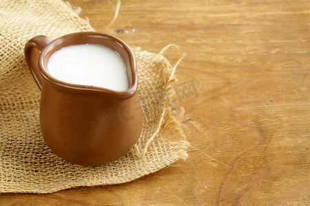 Ceramic brown jug full of milk, rustic style