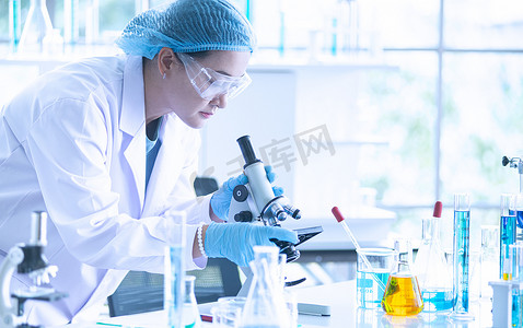 亚洲女科学家、研究员、技术员或学生使用显微镜进行研究或实验,显微镜是医学、化学或生物实验室的科学设备