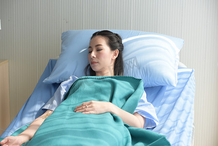 Aisan woman sleeping on bed in hospital