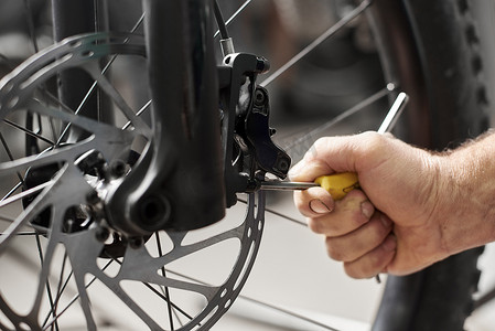 机修工摄影照片_关闭在自行车修理厂工作的男性机修工, 工人修理现代自行车