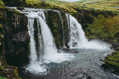 开化清水鱼摄影照片_冰岛柯克朱费尔瀑布。清水掉进小溪里。冷灰色的下午美丽的风景.