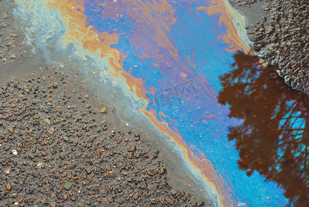 湿沥青上有油渍.桶被五颜六色的油流污染了.A.环境污染、石油外溢和环境问题的概念.