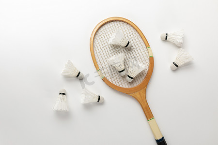 木制羽毛球拍和白色背景上的穿梭球的顶视图