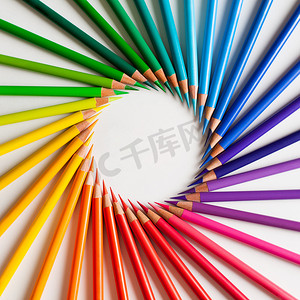 宽松摄影照片_蜡笔- -色彩艳丽的铅笔,宽松地排列在白色背景上.圆形框架.