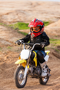 男孩骑着摩托车摄影照片_一个男孩赛车的肖像