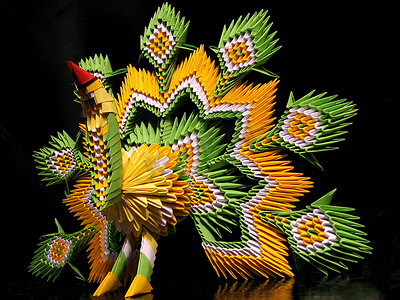 模块化摄影照片_图孔雀绿色, 黄色和白色与红色的嘴, 在技术模块化折纸上的黑色背景。手工鸟