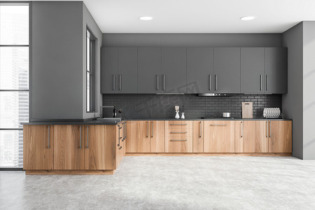 现代化厨房的内部，有灰色和砖墙，混凝土地面，木制台面，内置水池和炊具以及灰色橱柜。3d渲染