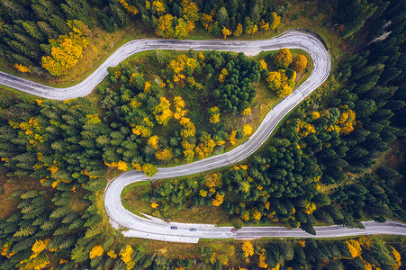 俯瞰公路摄影照片_弯弯曲曲的道路在森林里. 公路的空中图像。 Forre