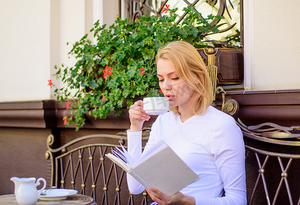 女人在户外喝咖啡露台。书休闲概念。杯好咖啡和愉快的书最佳组合完美的周末。女孩每天早晨喝咖啡在同一个地方每日礼节