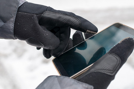 uses摄影照片_Man uses smartphone in winter