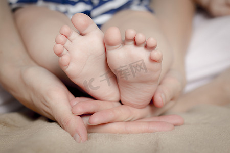 温柔的触摸。她手里拿着小宝宝脚的女人