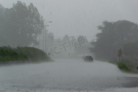 强风暴与大雨在路上与汽车能见度低。恶劣天气下驾驶危险的概念.