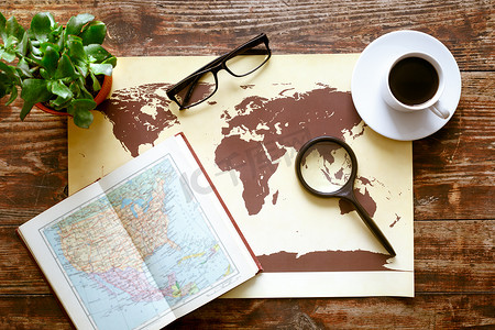 世界地图摄影照片_世界地图上木桌顶视图的咖啡