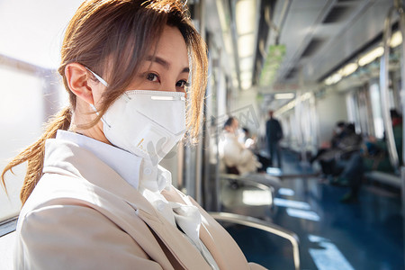 多职业人物摄影照片_年轻女人戴口罩坐地铁