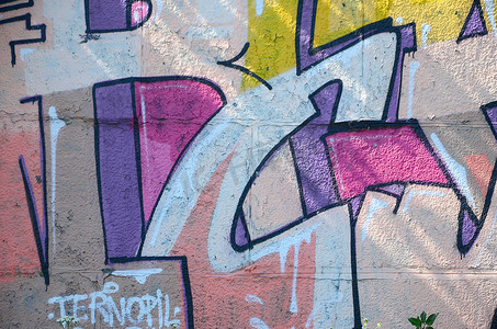 涂鸦画碎片。在街头艺术文化的风格上装饰着漆渍的旧墙。彩色背景纹理在温暖的色调.