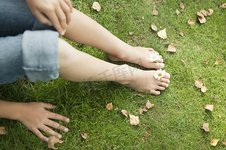 年轻女孩的腿和脚，用鲜花脚趾之间的顶视图.