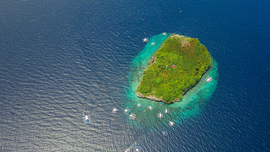 游客在美丽清澈的海水水落在奥斯洛布，菲律宾宿雾市附近的苏密隆碧海岛屿海滩游泳沙滩的鸟瞰图。-增强颜色处理.