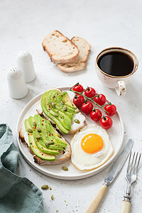 牛油果咖啡摄影照片_用牛油果、煎蛋、西红柿和咖啡烤面包。健康早餐食品