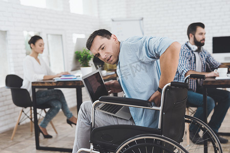 轮椅上的残疾人在办公室工作。他觉得病了.