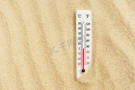 炎热温度计摄影照片_炎热的夏天沙中的温度和华氏温标温度计。环境温度加2度