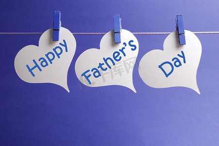 快乐的父亲一天消息写在白心形状标签挂在蓝钉上一线蓝色的背景上.