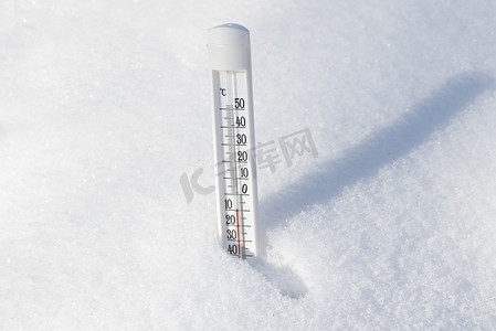 升旗飘扬动图摄影照片_温度计在雪中飘扬,显示出低温.冬季的概念