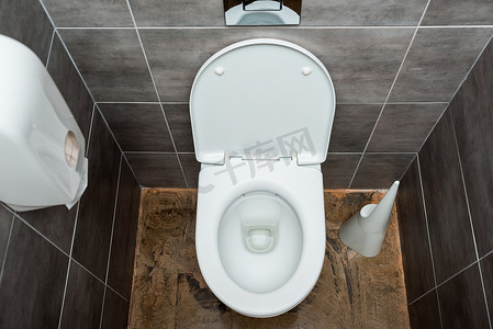 卫生间装饰摄影照片_用灰色瓷砖和马桶刷装饰的现代卫生间陶瓷清洁马桶