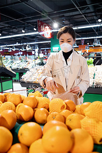 水果超市促销摄影照片_戴口罩的青年女人在超市挑选水果