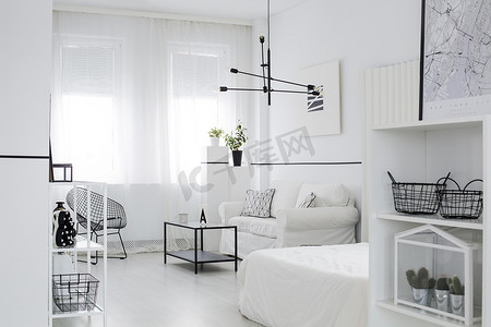斯堪的纳维亚风格的起居室内有窗户、黑灯、白色沙发和墙上的海报