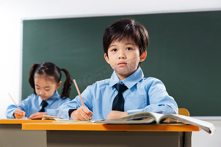 黑板写字摄影照片_小学生在教室里上课